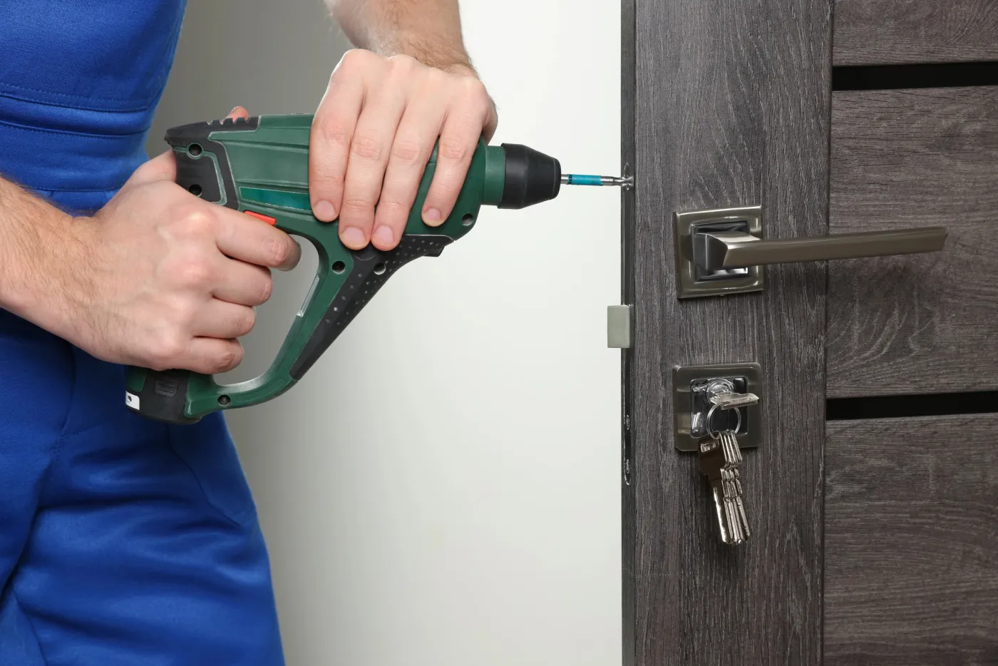 Serrurier fixant une serrure de sûreté sur une porte des hauteurs de Ménilmontant